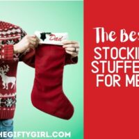 a man in a christmas sweater holding up a red Christmas stocking embroidered with the word Dad. Text overlay says The Best Stocking Stuffers for Men